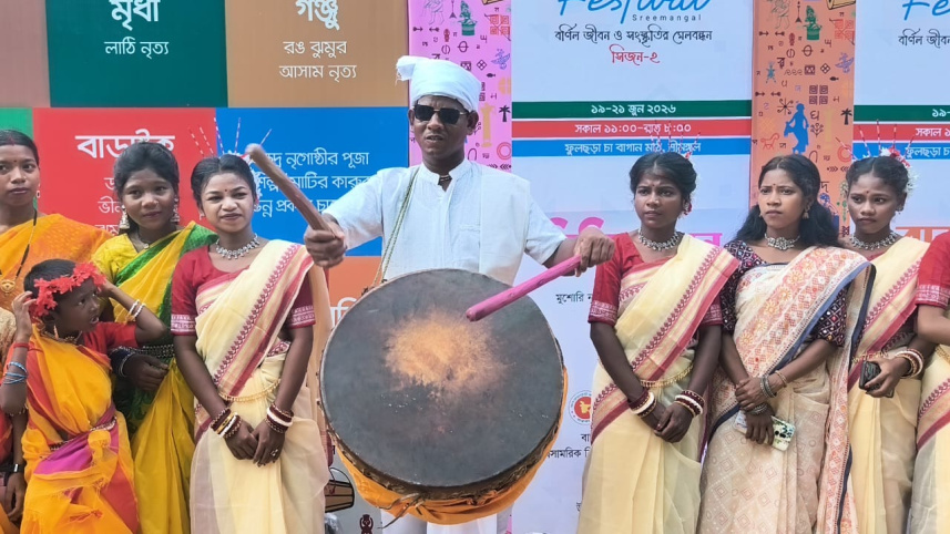 Dressed in traditional white clothing and a turban, Robi Munda plays the nagara at the Harmony Festival