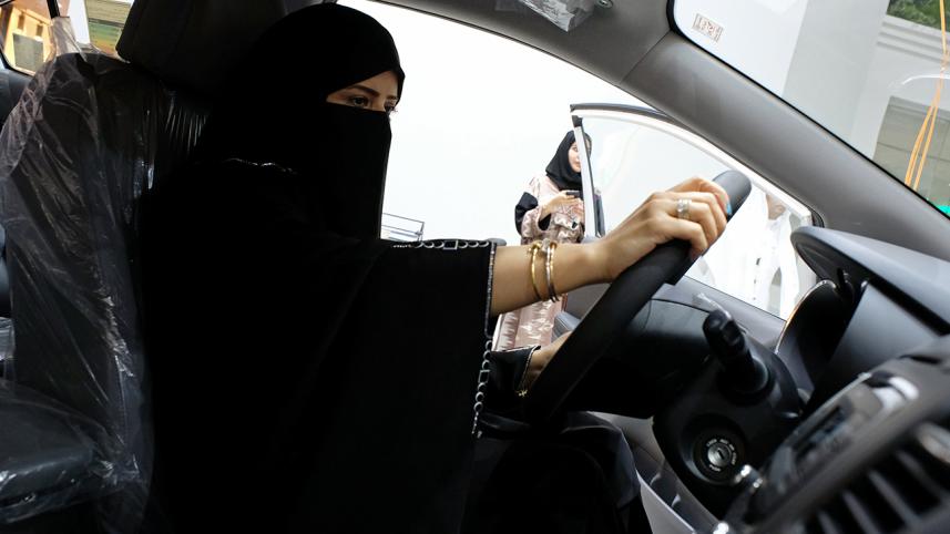 A Saudi woman checks a car