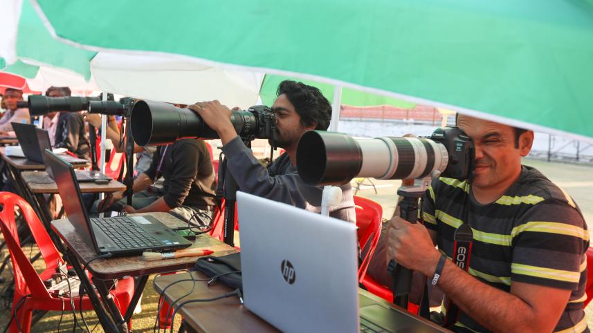 Journalists covering a sports event by taking pictures. 