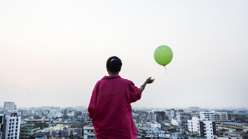 A mourning daughter letting go of a balloon to grief her deceased mother.