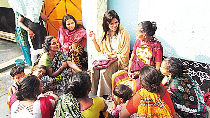Dr. Anika Haque leading a consultation session with women in a Dhaka slum.