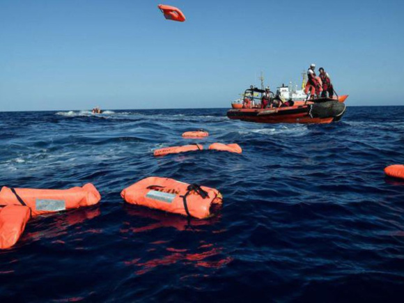 A rescue worker throws life jackets towards migrants at sea. Despite the dangers of crossing the Mediterranean, thousands of Bangladeshis continue to take irregular routes to Europe in search of better opportunities.