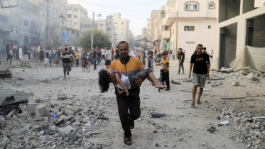 A Palestinian man carries a wounded girl at the site of Israeli strikes.png