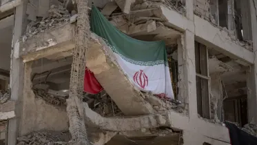 An Iranian flag hangs on a building targeted during Israeli attacks on a residential area in Tehran, Iran, on August 11, 2025, following the ceasefire between Iran and Israel after the 12-day war. Photo: AFP