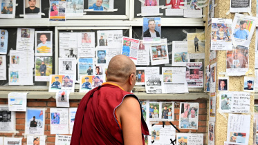 A Buddhist monk looks at photographs of missing and deceased people pasted on wall outside Tribhuvan University Teaching Hospital, following flash floods and a mudslide, in Kathmandu, Nepal, September 1, 2026. Photo: Reuters