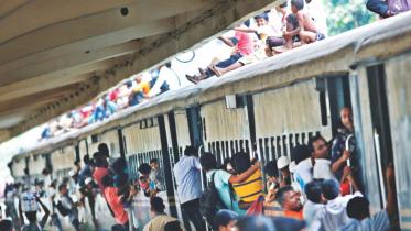 In the rush to get home for Eid, people jostle for seats at a stationary train at Kamlapur Railway Station.