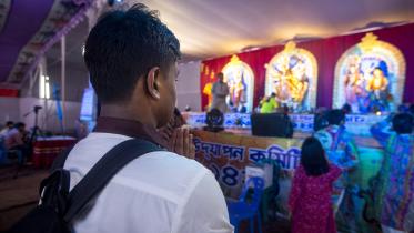 A student wearing his school's uniform while praying.  