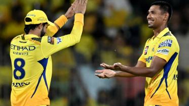 Chennai Super Kings' Mustafizur Rahman (R) celebrates with teammate after taking the wicket of Gujarat Titans' Rahul Tewatia (not pictured) during the Indian Premier League (IPL) Twenty20 cricket match between Chennai Super Kings and Gujarat Titans at the