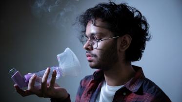 Person trying to use their asthma spacer.