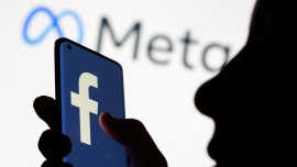 Woman holds smartphone with Facebook logo in front of a displayed logo for Meta in this illustration picture taken October 28, 2021. Photo: Reuters